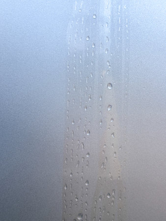A blue background with a pattern of water droplets. The droplets are arranged in a way that creates a sense of movement and energy. Scene is one of fluidity and motionの写真素材