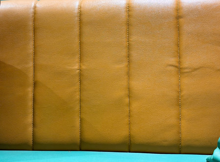 The couch has a tan and green striped back, with a brown leather finish. The stripes are clearly...