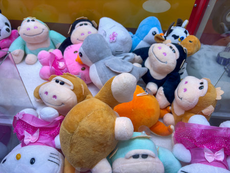 A bunch of stuffed animals are in a display case, including a monkey, a cat, a dog, a bird, a fish, and a cowの写真素材