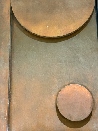 A metal surface with a circle and a square on it. The circle is smaller than the squareの写真素材