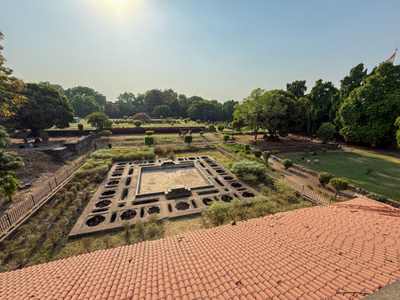 A large courtyard with a red roof and a small pond. The courtyard is surrounded by trees and has a peaceful atmosphere, Shaniwar Wada Pune.の写真素材
