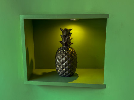 A pineapple is sitting in a green box. The pineapple is lit up and it looks like it is glowingの写真素材