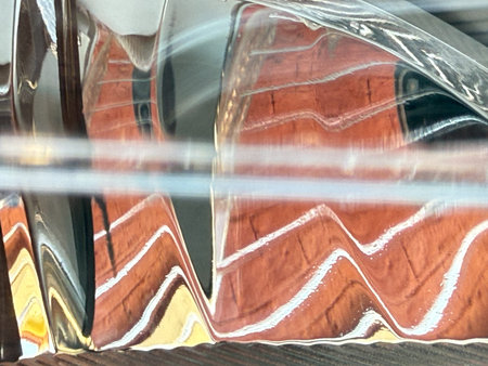 A reflection of a building is shown in a glass. The reflection is distorted and blurry, giving the...