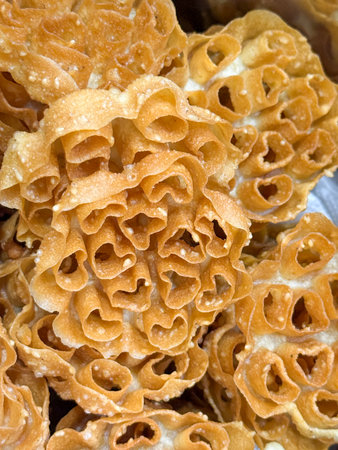 A bunch of golden pastries with a heart shape. They are arranged in a pile.の写真素材