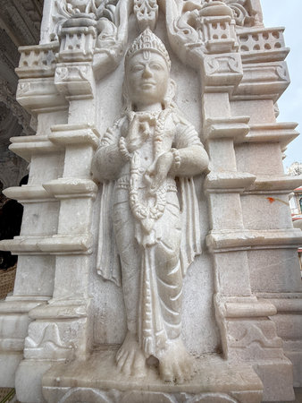 A statue of a woman holding a garland. The statue is white and has a serene expressionの写真素材