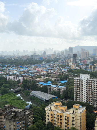 A cityscape with a blue sky and a few clouds. The city is full of tall buildings and a river runs through itの写真素材