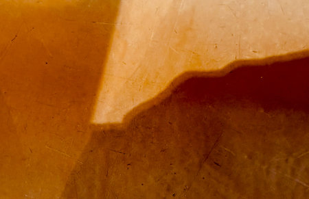 A brown surface with a shadow on it. The shadow is on the left side of the surface