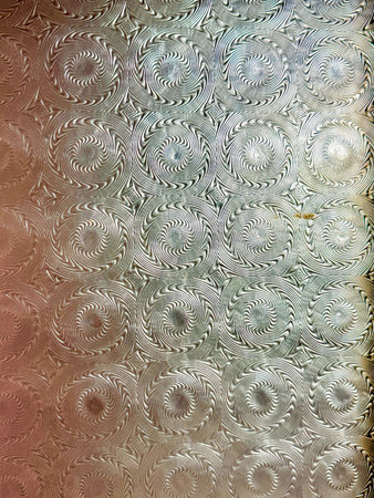 A glass wall with a pattern of circles. The circles are of different sizes and are arranged in a way that creates a sense of movement and depthの写真素材