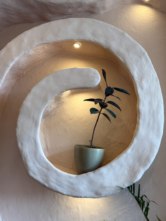 A plant is sitting in a pot on a shelf. The shelf is shaped like a letter A