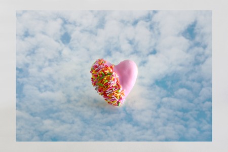 Heart shape of donut covered by pink chocolate rainbow sprinkle decoration on the sky,Valentine dayの写真素材