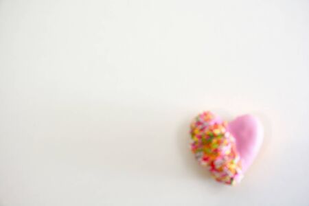 Heart shape of donut covered by pink chocolate rainbow sprinkle decoration on isolate,Valentine dayの写真素材