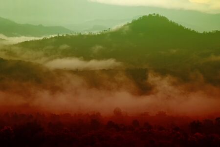 View landscape with silhouettes of mountains range with mist or covered by heavy fogの写真素材