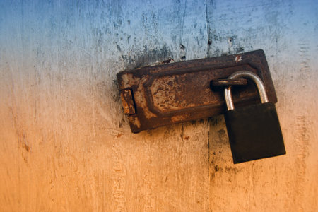 Old wooden doors locked by rusty padlock,iron latch,key lock