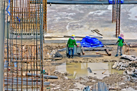 construction worker assembling scaffold stake on building site