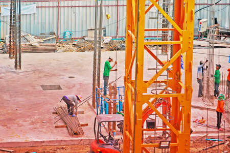 construction worker assembling scaffold stake on building site,selective focusのeditorial素材