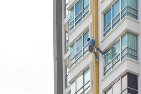 People wipe the glass on the block,Sprinkle from tall buildingsの写真素材