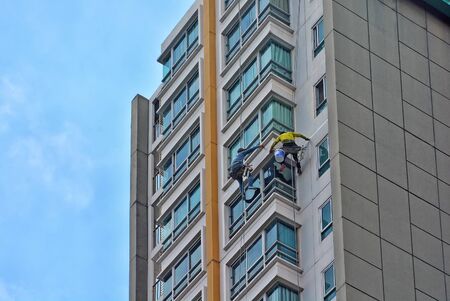 People wipe the glass on the block,Sprinkle from tall buildingsの写真素材