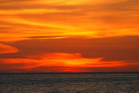 Orange light in the twilight on sea.の写真素材