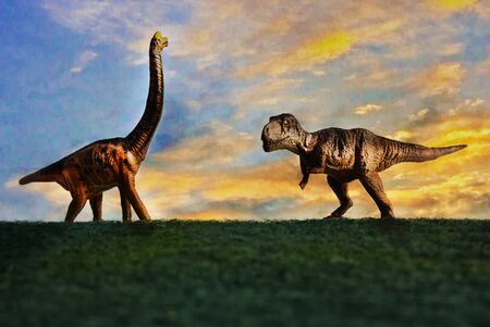 Tyrannosaurus rex or t-rex infront colorful sky and foliage in backgroundの写真素材
