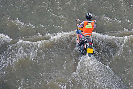 more floods and flooded motorcycle, motorcycle flood water on a roadのeditorial素材