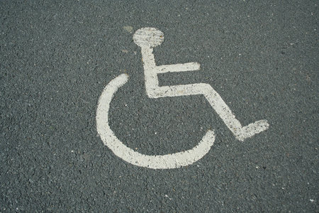 an image of a handicapped sign painted in a parking lot spaceの写真素材
