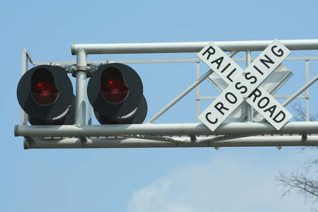 Railroad crossing sign  with light on blue skyの写真素材
