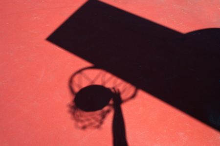 A Shadow Basketball player dunking on red courtの写真素材