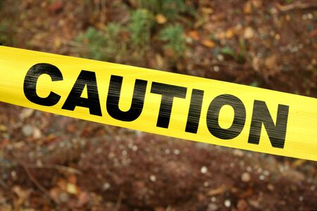 Yellow Caution Tape against a dirt backgroundの写真素材