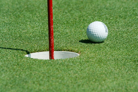 A Golf ball near the cup