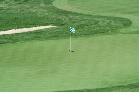 A green flag on a golf greenの写真素材