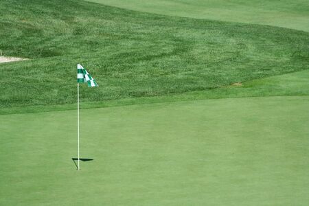 A green flag on a golf greenの写真素材
