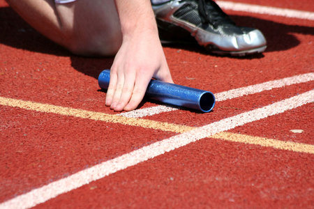 Runner in the starting blocks with baton
