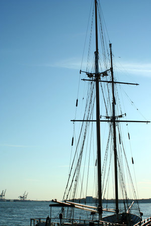 A ship mast and rigging against blue sky