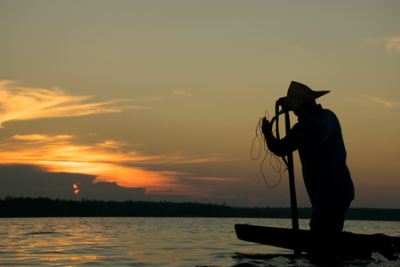 Fisherman action when fishing during sunsetの写真素材