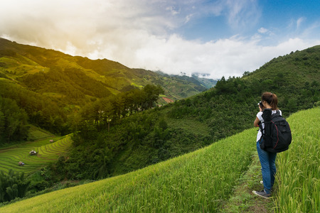 woman traveler backpacker taking a photo of rice terrace at Mu Cang Chai, Yen Bai, Vietnam.の写真素材