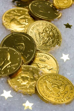 Gold chocolate coins on ice and star backgroundの写真素材