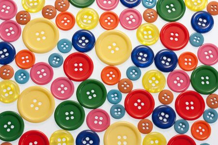 Lots of bright coloured buttons on white full frame viewの写真素材