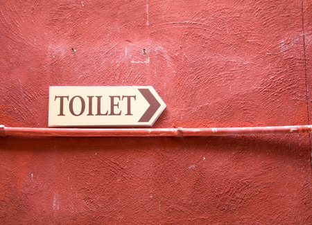 toilet plate signage on red wall textureの写真素材