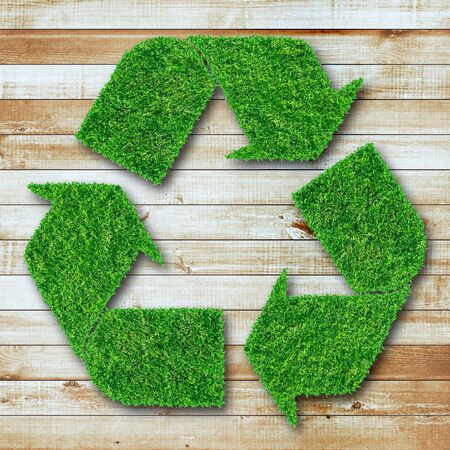 Recycle symbol from grass on wood background の写真素材