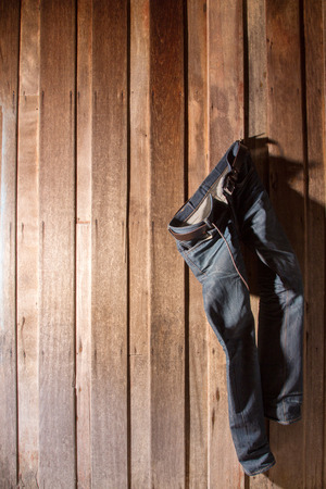 Jeans hanging wooden wallの写真素材