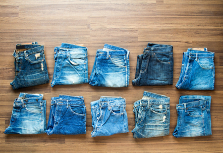 Collection jeans stacked on a wooden background, View from aboveの写真素材