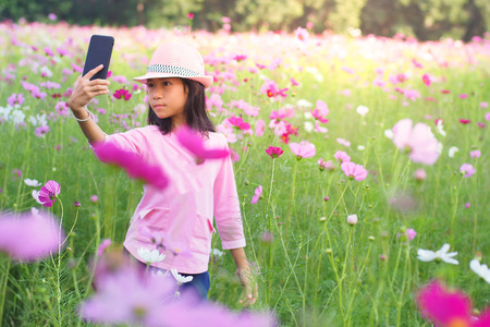 Girl selfie camera selfie smart phone in flower gardenの写真素材