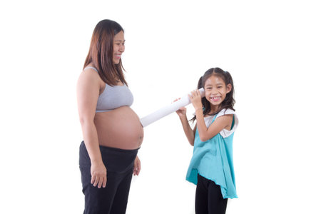 Pregnant woman and kid girl listening her baby heart soundの写真素材