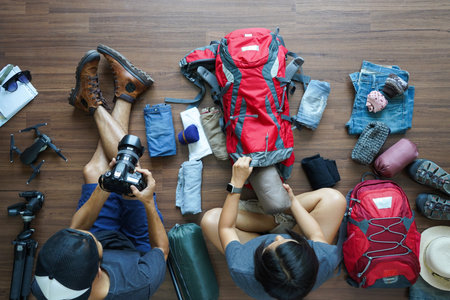 Overhead view of Traveler's Young couple planning honeymoon vacation trip with holding camera and...