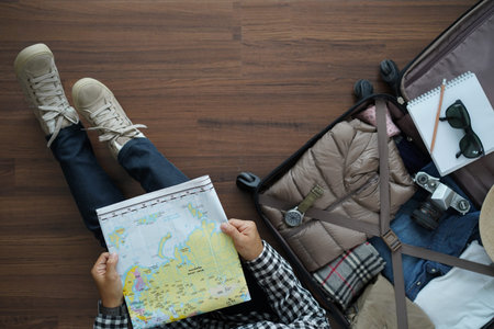 Overhead view of traveler woman plan and backpack planning vacation trip with map. Top view on...
