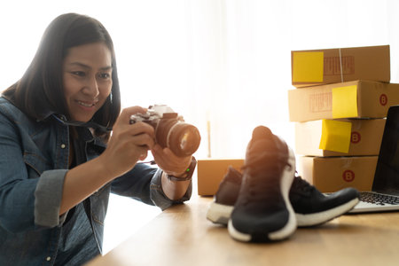 Women business owner taking photo to shoes with digital camera, for post to selling online on the...