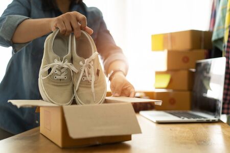 Women business owner work at home selling shoes onlineの写真素材