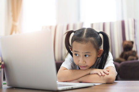 Asian little girl student learning virtual internet online at homeの写真素材