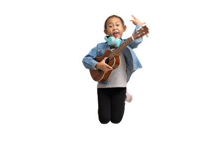 Happy Asian child girl jumping play ukulele, isolate on white background.