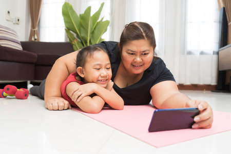 Asian woman fat with little girl using smart phone